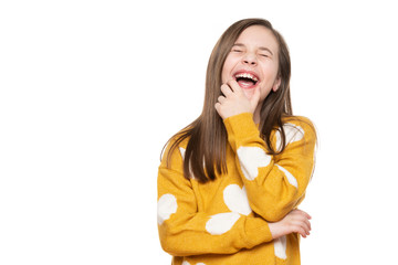 Waist up studio portrait of an adorable young girl laughing with excitement, closed eyes, isolated on white backgroud. Human emotions and facial expressions concept.