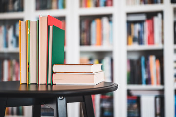 Glasses on stack of books. Library in the background. Books and glasses.