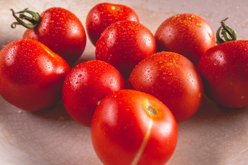 Organic ripe tomatoes in old white plate