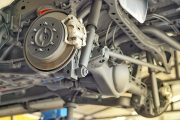 Disc brake of the vehicle for repair, in process of new tire replacement.  Car brake repairing in garage.Selective focus disc brake on car, in process of new tire replacement.Close up.