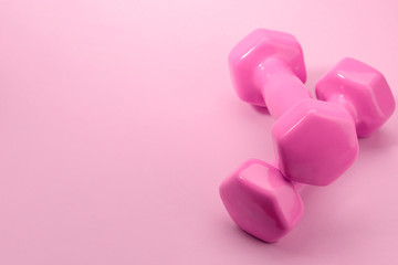 Pair of dumbbells on pink background with copy space