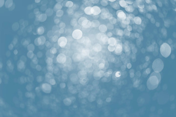 White bokeh lights over blue background