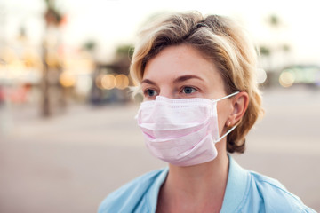 A portrait of woman with medical face mask outdoor. People, medicine and healthcare concept