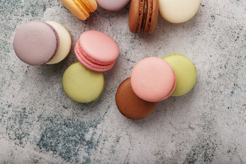 French macaroni cookies of different colors are on the gray table. Still life of confectionery.