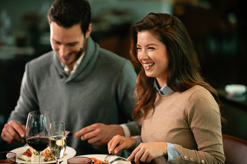 Happy loving couple enjoying in restaurant. Young couple enjoying in food.