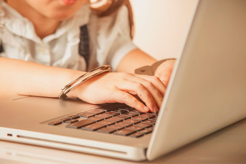 Slave of office work.Portrait of handcuffed persons hand on laptop.
