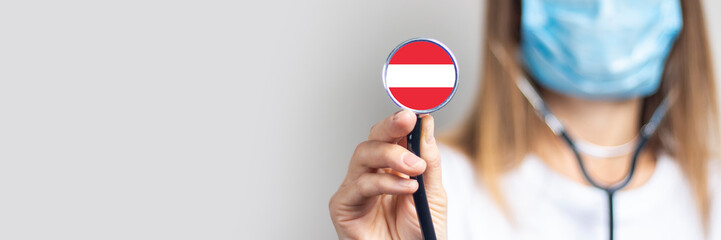 female doctor holding a stethoscope on a light background. Added flag of Austria. Concept medicine,...