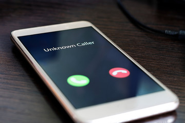 Unknown caller. Smartphone with incoming call from an unknown number at night. Incognito or...