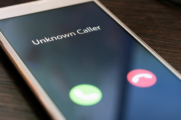 Unknown caller. Smartphone with incoming call from an unknown number at night. Incognito or anonymous