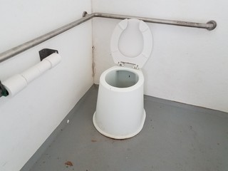 dirty toilet with metal bars in bathroom or restroom