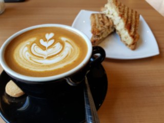 cup of coffee with whipped cream on wooden background