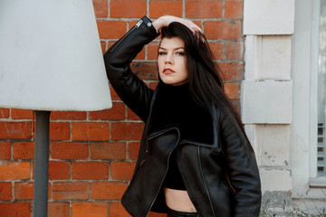 Portrait of a girl in the city. Beautiful brunette in the city streets. Stylish woman travels the cities of Europe.