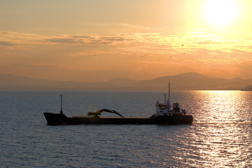 Fototapeta premium cargo ship, sailing at sunset