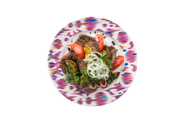 grilled vegetable salad with grilled beef, zucchini, red onion, tomatoes on plate isolated on white background