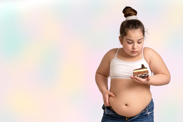 Girl with cake staying on the white background. Obesity problems..