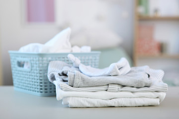 Clean and fresh baby clothes stacked on a table. Washing baby clothes.