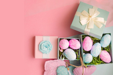 Gift boxes with easter blue and pink eggs in pink and blue ribbons on a light pink fashionable background. Copyspace. Concept of sales, discounts, easter gifts and shopping. With place for inscription