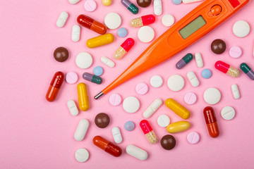 Thermomètre et médicaments avec arrière-plan rose