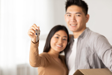 Thai man and woman showing key from their flat