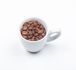 Tasse blanche remplie de grains de café