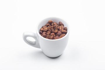 Tasse blanche remplie de grains de café