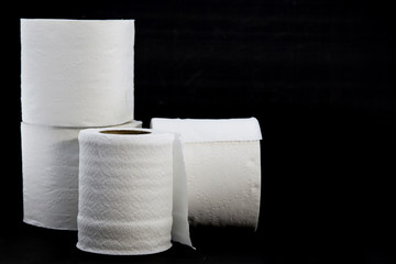 white toilet roll or toilet paper on black background with space for text.