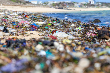 Closeup plastic trash on the sandy beach of a tropical sea