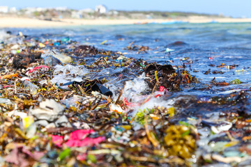 Closeup plastic trash on the sandy beach of a tropical sea © nelasova