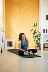Mid-adult fit slim Caucasian brunette practicing morning yoga.	