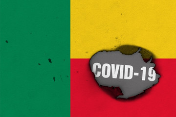 Flag of Benin with burned out hole showing Coronavirus name in it. 2019 - 2020 Novel Coronavirus...