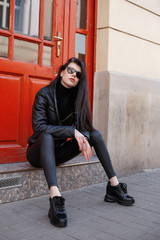 Portrait of a girl in the city. Beautiful brunette in the city streets. Stylish woman travels the cities of Europe.
