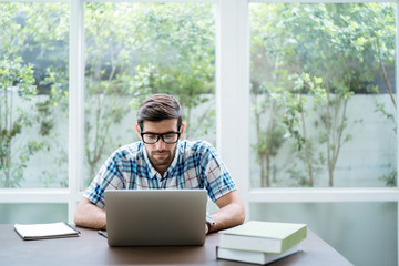 Freelance and working online, The young man is working with a laptop over the internet at home.