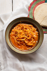 Mexican chicken tinga with chipotle sauce on white background
