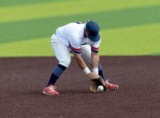 Young Boy catching and throwing the ball during a competitive baseball game