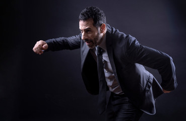 manager con barba vestito in abito, corre velocemente- Isolato su sfondo nero