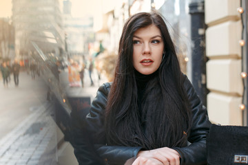 Portrait of a girl in the city. Beautiful brunette in the city streets. Stylish woman travels the cities of Europe.