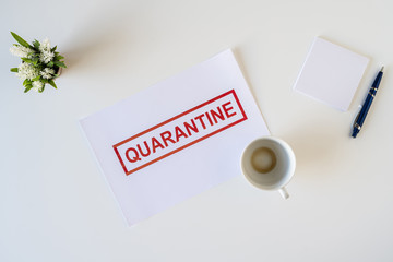 Abandoned workplace of a sick employee in the office due to coronavirus and quarantine with a cup of finished coffee. Worldwide pandemic concept