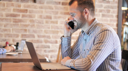 Beard Casual Man Talking on Phone, Sitting Outdoor