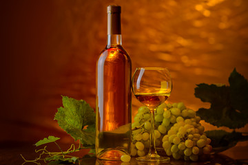 Wine. A bottle and glass of white wine with a bunch of ripe white grapes