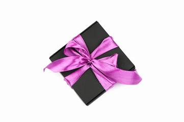 Gift black packaging with a purple bow on a white background. Cut out the background.
