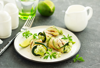 Zucchini rolls stuffed with cottage cheese and avocado. Snack. Selective focus.