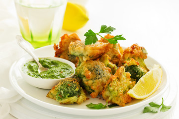 Fried broccoli in batter with green sauce. Selective focus