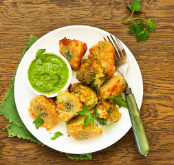 Fried broccoli in batter with green sauce. Selective focus