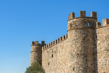 Fototapeta na wymiar Side of the Alconchel castle, with its elegant battlements, in the southwest of Spain
