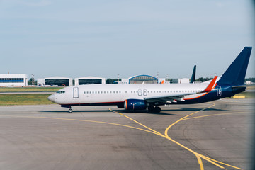 Obraz premium Side view of modern lowcost boeing waiting for take-off permit in airport terminal, international commercial vehicle parking during voyage check in, jet airliner for passengers transportation