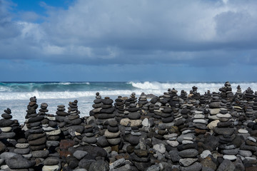 Stones pyramid on pebble beach symbolizing stability, zen, harmony, balance.