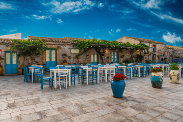 Typical italian outdoor cafe in beautiful and colorful sicilian village Marzamemi in province of Syracuse in Sicily, Italy