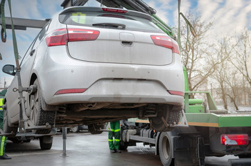 Tow truck lifting the car for improper parking. The utility service removes the wrongly parked...