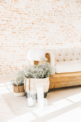 Vintage living room with white wooden sofa and beige brick wall