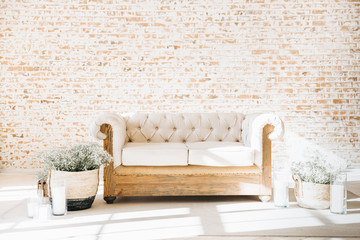 Vintage living room with white wooden sofa and beige brick wall